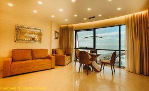 a living room with a couch and a table and chairs at Apartment Natalia Sea Towers in Batumi