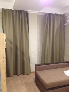 ソチにあるRytsar Sochi Dagomysのベッドルーム(緑のカーテン、ベッド1台付)