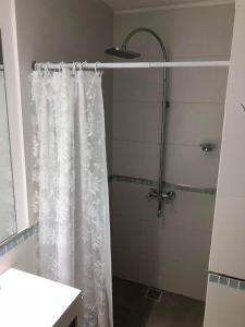 y baño con ducha con cortina blanca. en Residencia Pasco en Rosario
