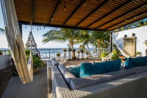 un sofá en un porche con el océano en el fondo en Hotel Vista Oceana Sayulita en Sayulita