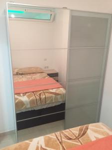 マスパロマスにあるApartamento Luxuryのベッドルーム1室(鏡付きクローゼット、ベッド2台付)