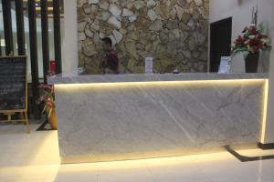 einen Tresen in einem Restaurant mit einer Steinmauer in der Unterkunft Green Garden Hotel in Tuban