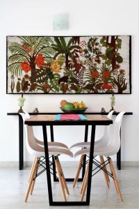 ヒッカドゥワにあるPlantation Houseのダイニングテーブル(椅子付)が備わります。壁には絵画が飾られています。
