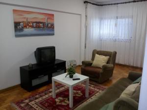salon z kanapą, telewizorem i stołem w obiekcie Apartamento Do Silva w mieście Mirandela