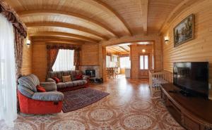 a living room with couches and a flat screen tv at Solnce Karpat in Polyana