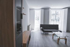 sala de estar con sofá negro y mesa en Plaza Mayor Apartment, en Ourense