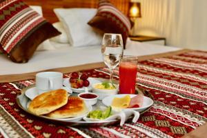 a tray with a plate of food and a glass of wine at Yakana Hotel in San Pedro de Atacama