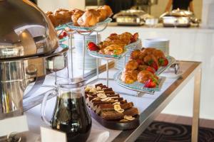 um buffet com vários pratos de pastelaria e pastelaria sobre uma mesa em Oaks Cypress Lakes Resort em Pokolbin