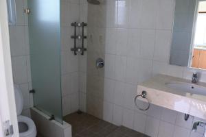 a bathroom with a shower and a toilet and a sink at Diyar Villas Puncak M4/12 in Puncak