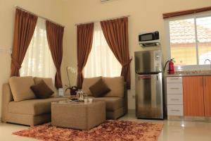 ein Wohnzimmer mit einem Sofa und einer Küche in der Unterkunft Diyar Villas Puncak M4/12 in Puncak