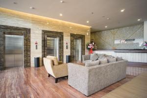 a living room with a couch and two chairs at Grand G7 Hotel Kemayoran in Jakarta
