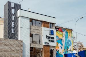 a building with a sign on the side of it at Express City Hotel in Shymkent