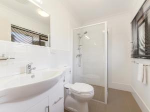 a bathroom with a toilet and a sink and a shower at Narimba Motel in Port Macquarie