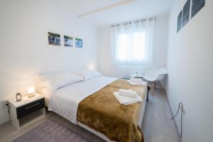una camera bianca con un grande letto e una scrivania di Saint Blaise Apartment a Dubrovnik