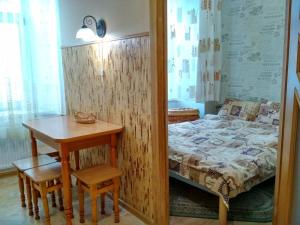 een slaapkamer met een tafel en een bed en een tafel en stoelen bij Apartment on Virmens'ka Street in Lviv