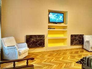 a living room with two chairs and a tv at Apartment on Virmens'ka Street in Lviv
