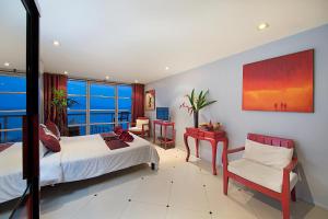 a bedroom with two beds and a table and a chair at Enjoy Beach in Bophut