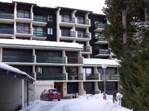 フォン・ロムーにあるAppartement Val Cristalの建物前の雪屋根付き駐車場