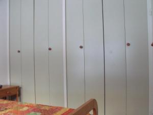una fila de armarios blancos en una habitación con una mesa en Appartement Val Cristal, en Font-Romeu
