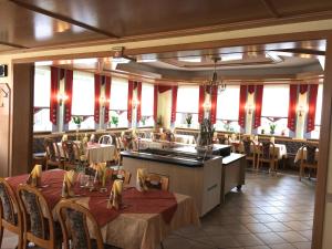a dining room with tables and chairs and windows at Hotel Sonnental in Neusorg