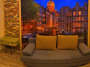 ein Sofa in einem Zimmer mit einem Bild einer Stadt in der Unterkunft ApartLux 2 in Tschernihiw