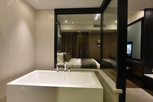 a bathroom with a white sink and a bedroom at SHANGHAI-DECO Hotel-Free shuttle bus to Pudong Airport and Disneyland in Shanghai +115 photos