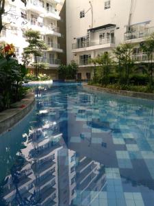 a swimming pool in front of a building at Gateway Pastuer by N Hospitality in Bandung