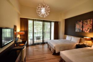 a hotel room with two beds and a chandelier at LeaLea Garden Hotels - Moon Lake in Yuchi