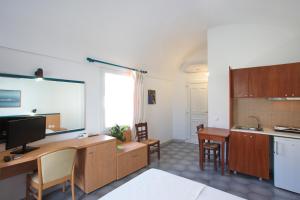 cocina con escritorio y TV en una habitación en SUN -RISE en Perissa