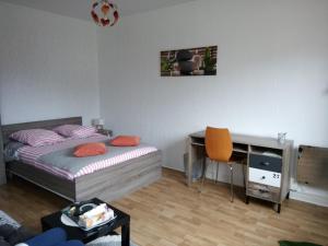 a bedroom with a bed and a desk with a desk at Studio centre ville tout confort in Nevers