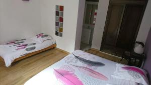 two beds in a small room with pink feathers at Camping White Rock in Castellane