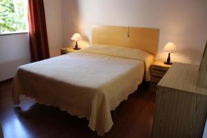 sypialnia z dużym białym łóżkiem z 2 lampami w obiekcie Residencial Martinho w mieście Lousã