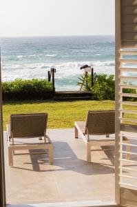 Duas cadeiras sentadas num pátio com vista para o oceano em Luxury Beach Villa (On the Beach) em Ballito