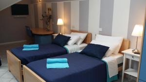 2 Betten in einem Hotelzimmer mit blauer Bettwäsche in der Unterkunft Central Park in Casarile