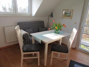 a dining room table and chairs with a couch at EIFEL Gästewohnung in Blankenheim