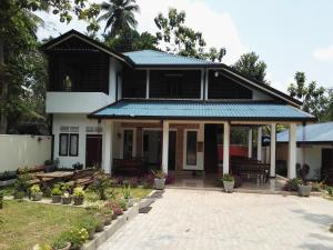 a black and white house with a blue roof at Leopard Rock Family Rest in Katunayake