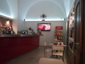 a restaurant with a bar with a tv on the wall at B&B miccoli in Grottaglie