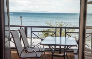 stół i krzesła na balkonie z widokiem na ocean w obiekcie Varka Apartment w mieście Makrýgialos