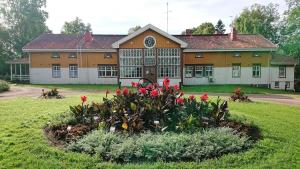 a large building with red flowers in front of it at Lepaan Kartanon Vierashuone in Lepaa