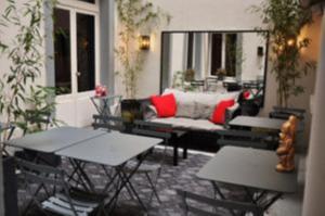 a patio with two tables and a couch and chairs at Alba Opéra Hôtel in Paris +90 photos