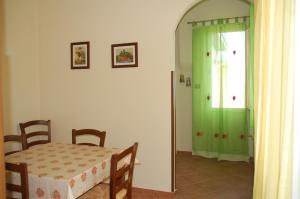 comedor con mesa y cortina de ducha verde en Casa Maria, en Puntalazzo