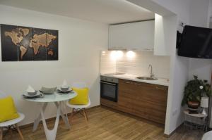 a kitchen with a small table and yellow chairs at M48 apartments in Belgrade