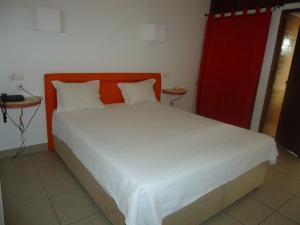 a bed with an orange headboard in a room at Torre Velha AL in Albufeira