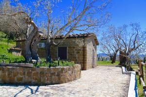 a small brick building with a tree in front of it at Il Giglio in Pettineo