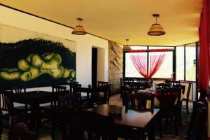 a restaurant with tables and chairs and a painting on the wall at Il Giglio in Pettineo