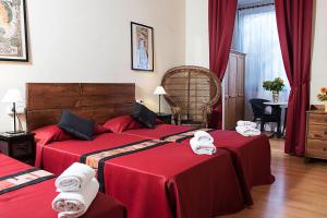 Habitación de hotel con 2 camas con sábanas rojas en Fashion House, en Barcelona