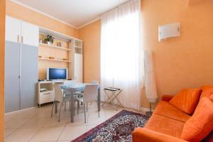 a living room with a couch and a dining room table at Bomboniera fronte mare ! in Viareggio
