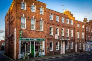 a large brick building with a store in front of it at The Abbey Hotel in Tewkesbury