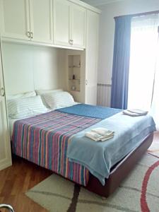 a bedroom with a bed with a striped blanket at Mezzocammino Short Rent Apartment - CIU5125 in Mostacciano