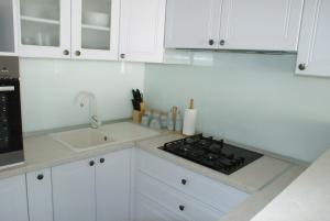a white kitchen with a stove and a sink at Apartman Old Town in Trogir